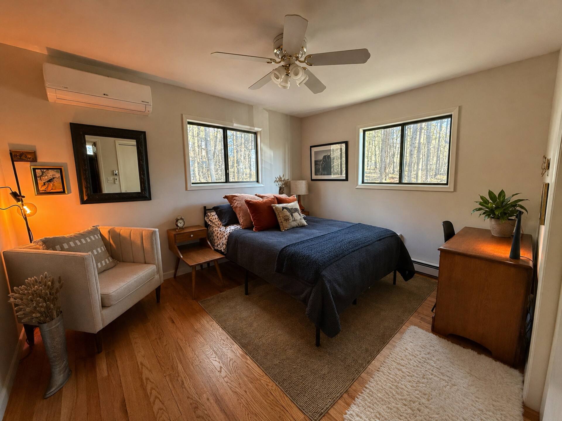 King bedroom with wood floors and sitting area