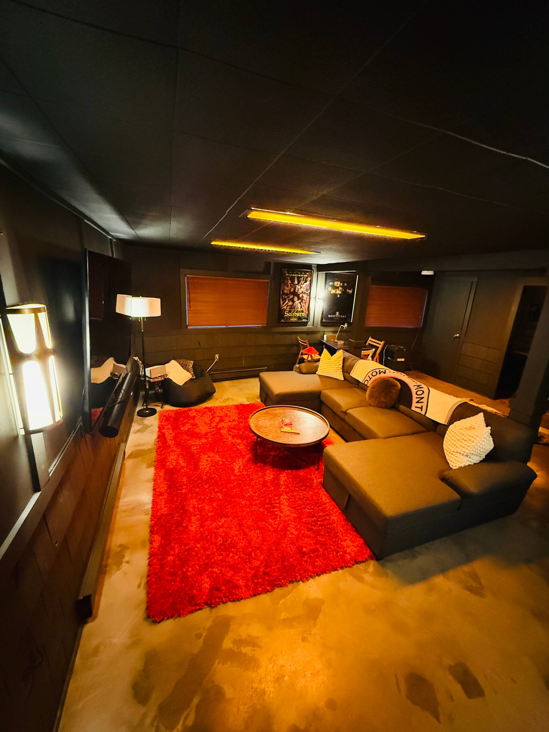 Home theater lounge with red rug and ambient lighting