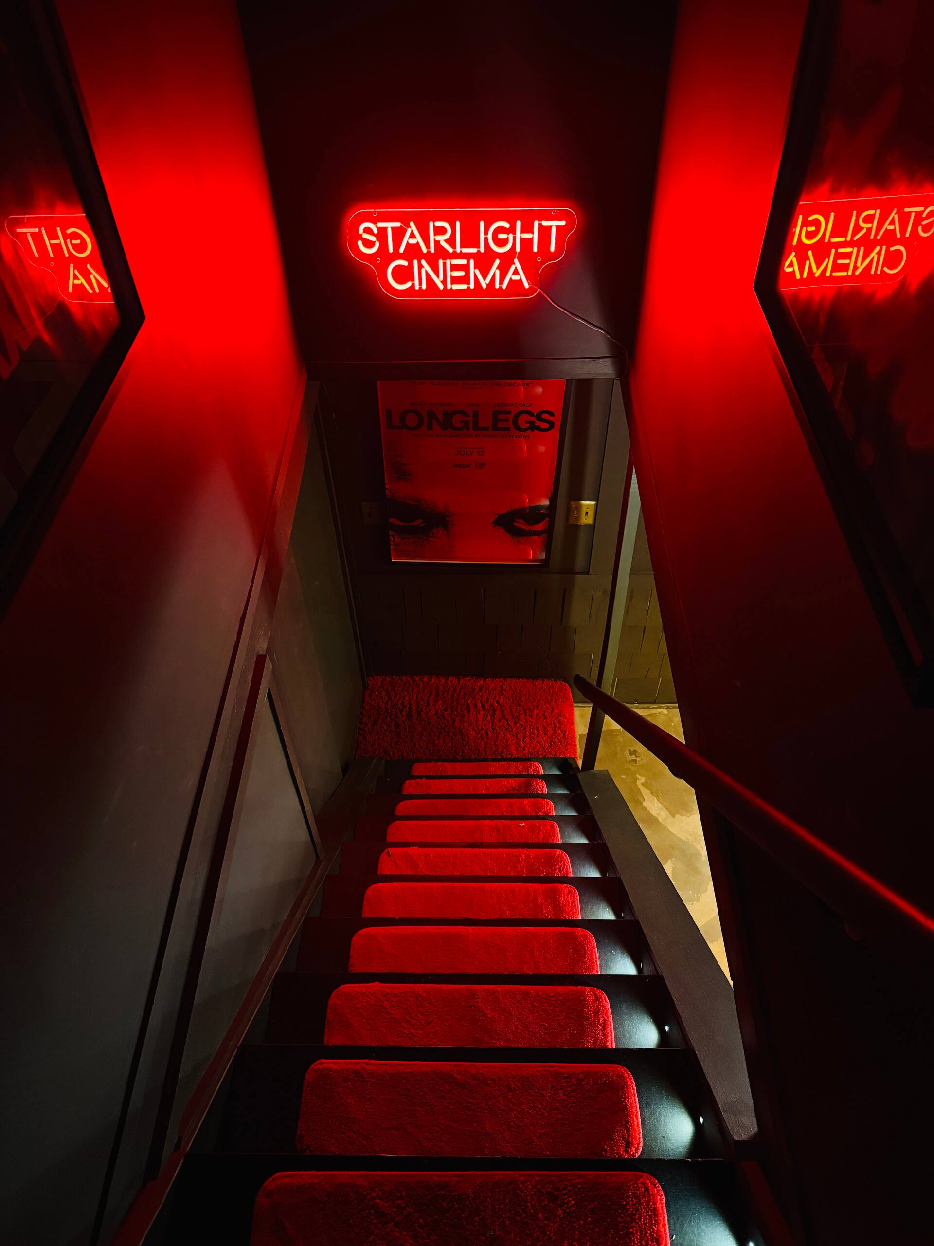 Stairs down to the Starlight Cinema in red neon