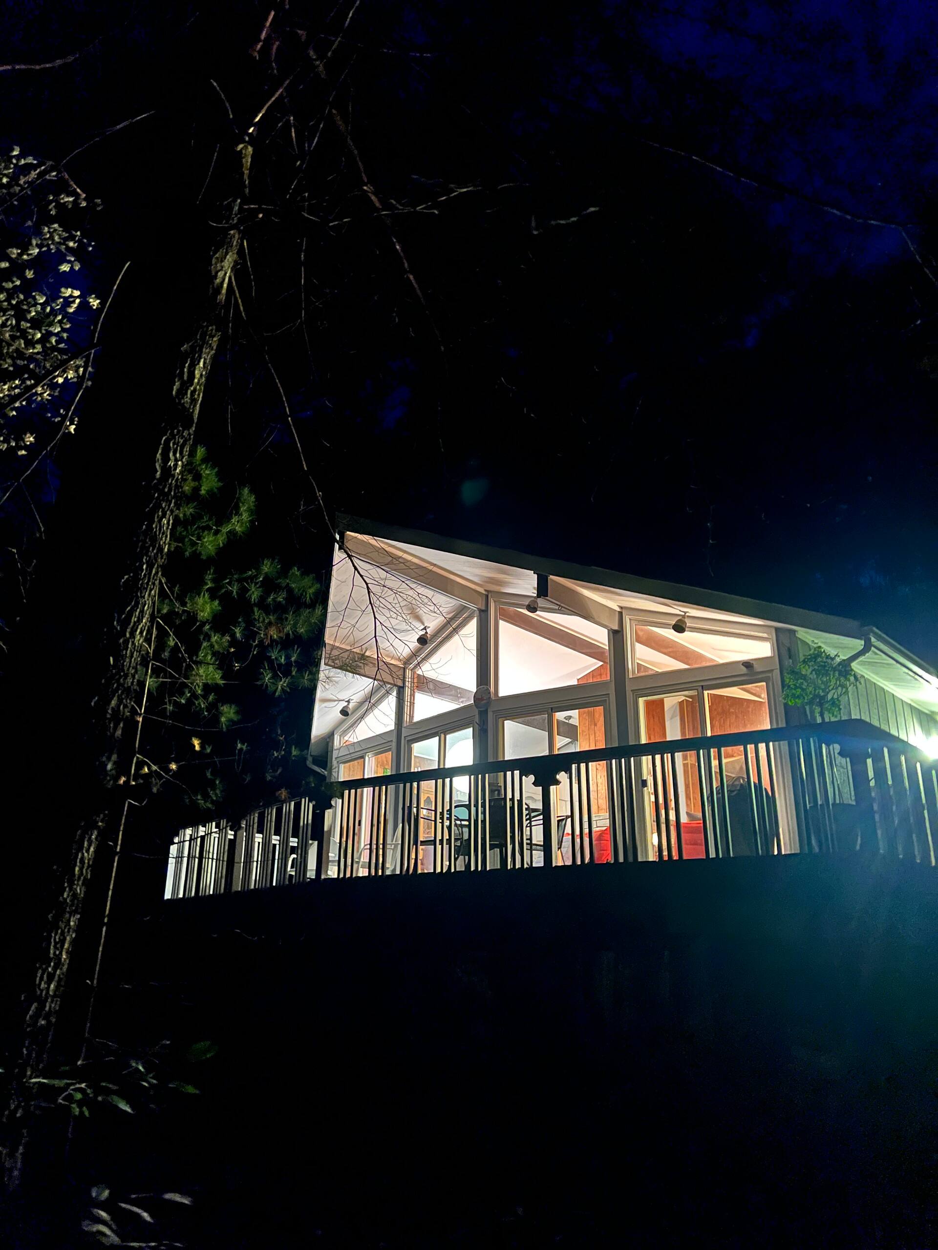 Starlight House lit up at night in the Catskills woods